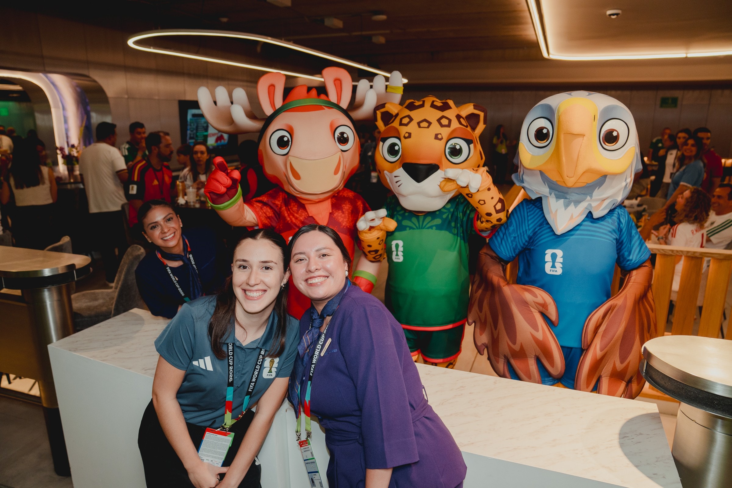 Staff posing with FIFA World Cup mascots at hospitality suite